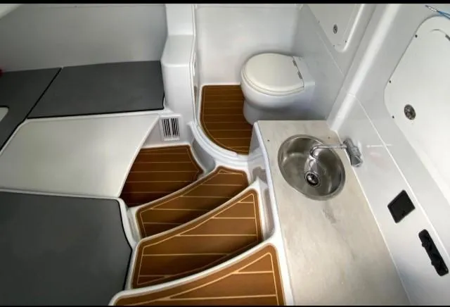 Slide: The Image of 2019 Yellowfin Center Console interior with sink, toilet, and cushioned seating. - 29