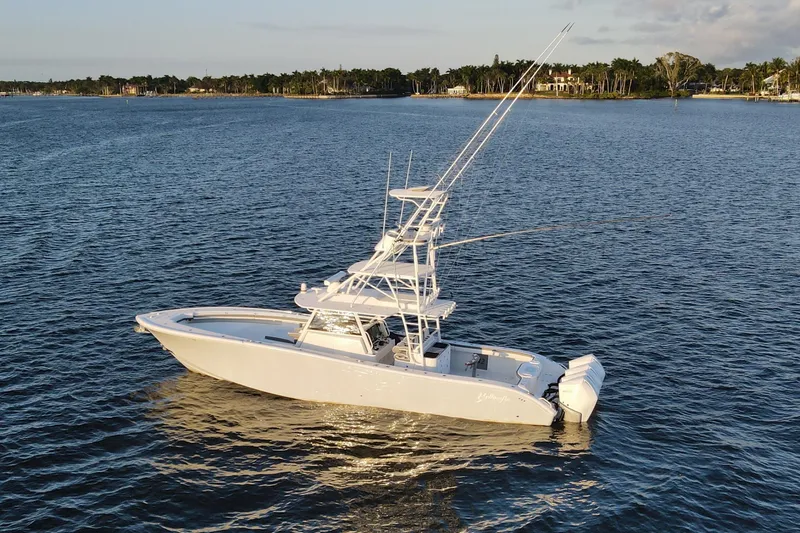 The Image of 2019 Yellowfin 42 Offshore boat on calm water, with scenic shoreline background. - 4
