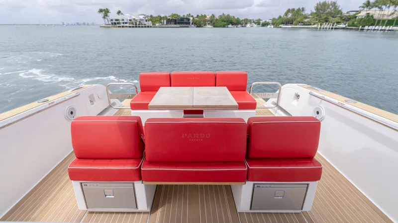 Slide: The Image of Pardo Yachts 38, 2023, featuring red seating and wooden table on water. - 23