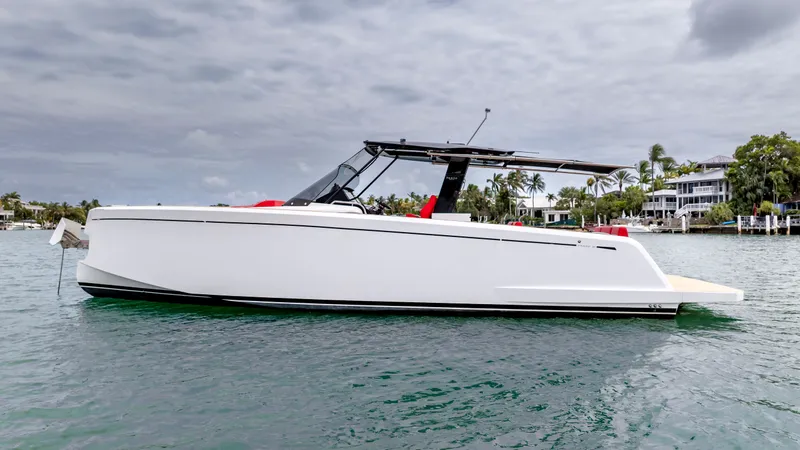 Slide: The Image of Pardo Yachts 38, 2023 model, cruising on calm waters near coastal homes. - 8