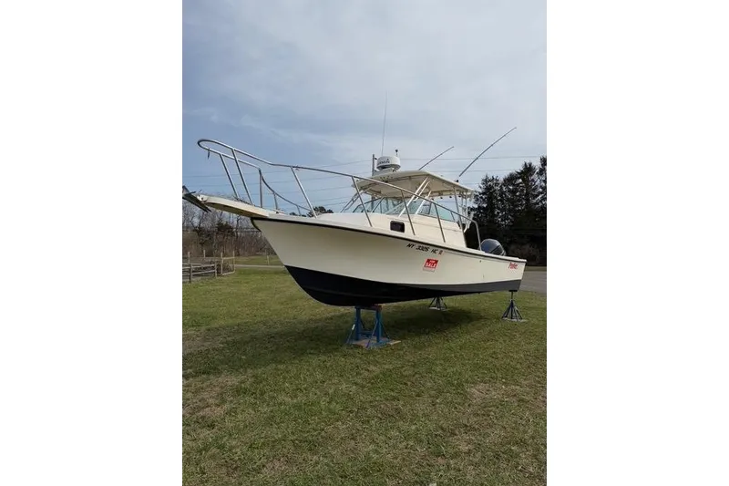 The Image of 2005 Parker 2501 Center Console boat on stands, displayed outdoors on grass. - 0
