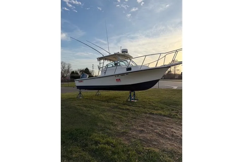 Slide: The Image of 2005 Parker 2501 Center Console boat on stands, displayed outdoors at sunset. - 11