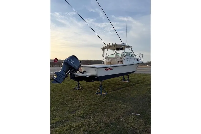 Slide: The Image of 2005 Parker 2501 Center Console boat on stands, Yamaha outboard, grassy area, clear sky. - 9
