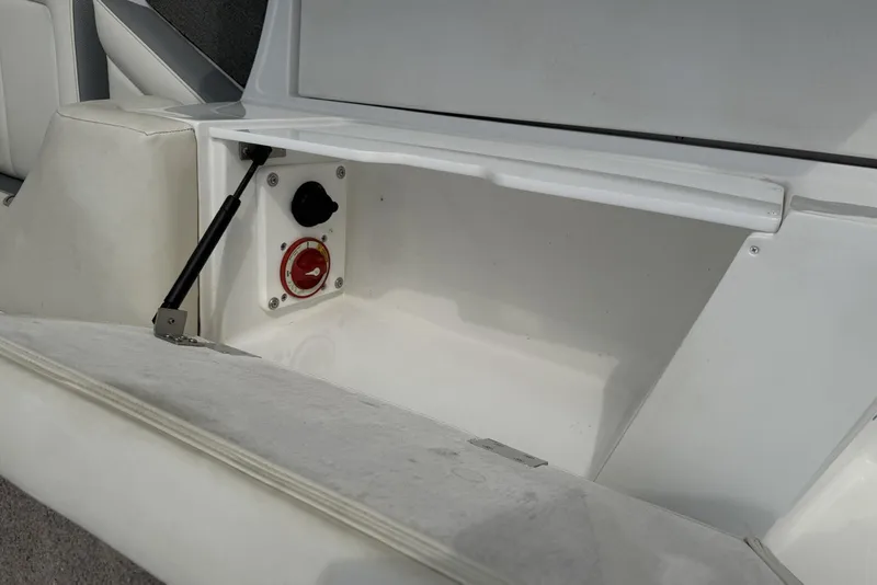 Slide: The Image of 2016 Cobalt 220 boat storage compartment with battery switch and hydraulic support. - 16