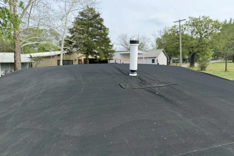 Slide: The Image of Black cover on a 2016 Cobalt 220 boat with a vent pipe, surrounded by trees and houses. - 18