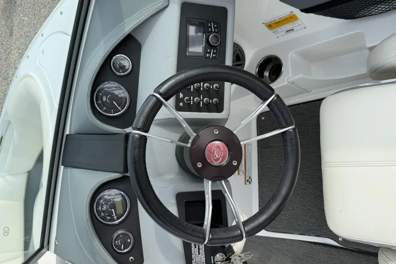 Slide: The Image of Steering wheel and dashboard of a 2016 Cobalt 220 boat, featuring gauges and controls. - 20