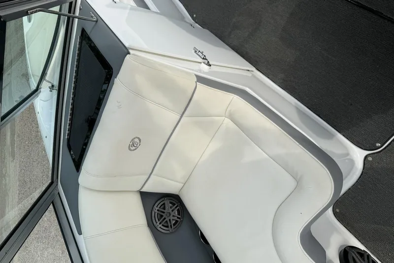 Slide: The Image of Interior of a 2016 Cobalt 220 boat featuring white cushioned seating and speaker. - 21