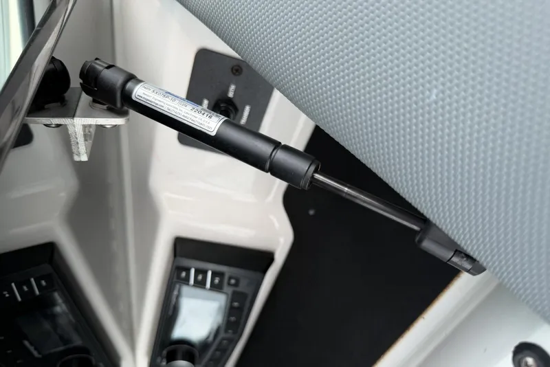 Slide: The Image of Gas strut mechanism in 2016 Cobalt 220 boat interior, showcasing control panels. - 22