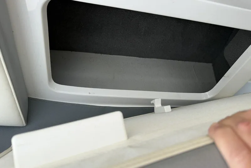 Slide: The Image of Storage compartment in a 2016 Cobalt 220 boat, featuring a clean, white interior. - 32