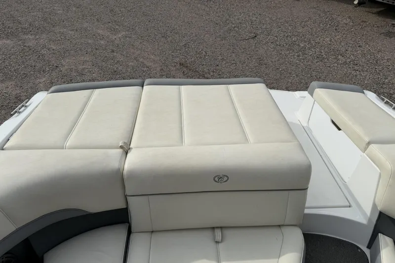 Slide: The Image of 2016 Cobalt 220 boat with beige cushioned seating on a gravel surface. - 38