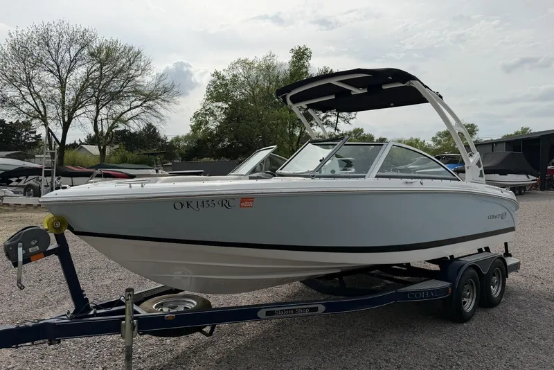 Slide: The Image of 2016 Cobalt 220 boat on trailer, parked outdoors with trees in the background. - 6