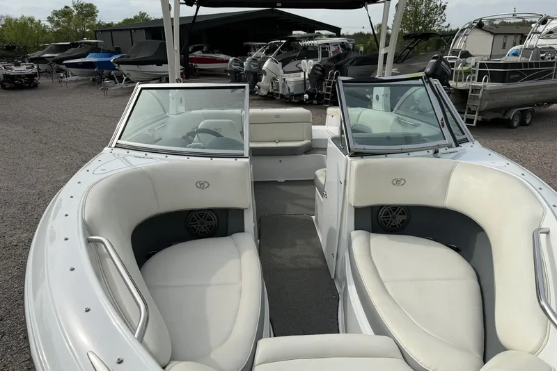 Slide: The Image of 2016 Cobalt 220 boat with white interior seating, parked among other boats. - 8
