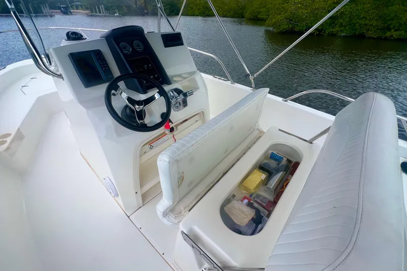 Slide: The Image of 2008 Boston Whaler 200 Dauntless boat interior with steering console and storage compartment. - 6
