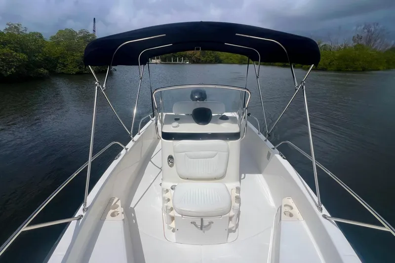 Slide: The Image of 2008 Boston Whaler 200 Dauntless boat with canopy on calm water. - 9