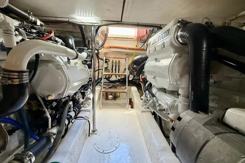 Slide: The Image of Engine room of a 2003 Riviera 40 Flybridge yacht, showcasing dual marine engines. - 100