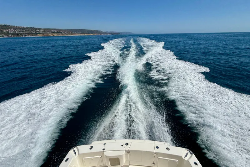 Slide: The Image of Riviera 40 Flybridge 2003 cruising, leaving a wake in the ocean under clear blue skies. - 102