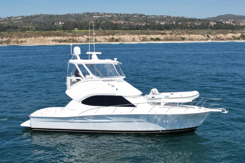 Slide: The Image of 2003 Riviera 40 Flybridge yacht cruising on the ocean near a scenic coastline. - 2