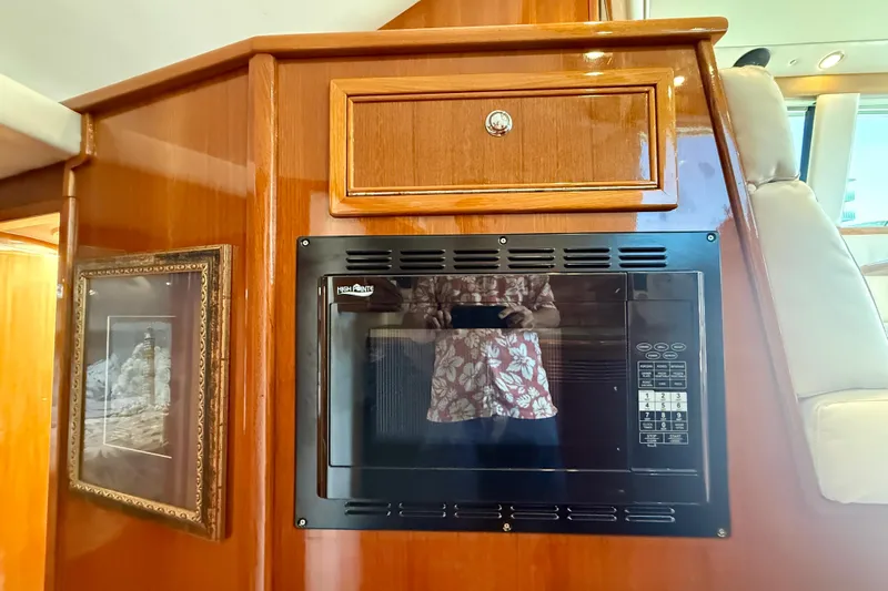 Slide: The Image of Interior of 2003 Riviera 40 Flybridge featuring a built-in microwave and framed artwork. - 30