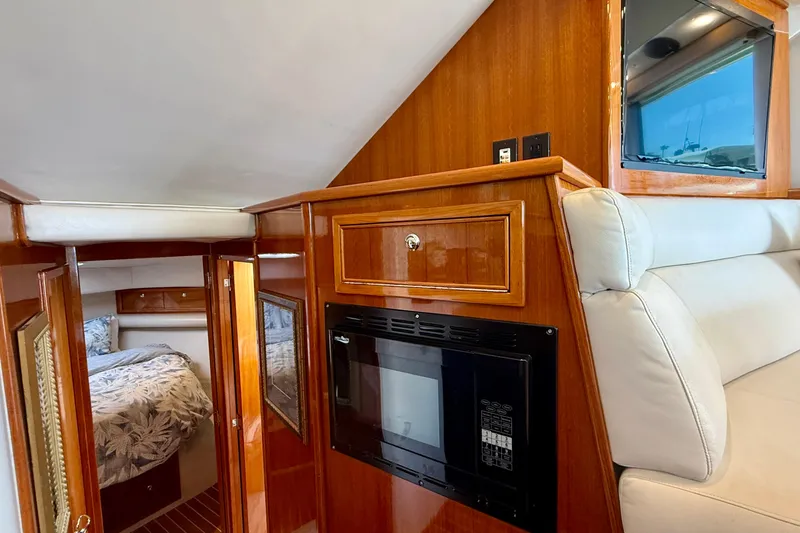 Slide: The Image of Interior of 2003 Riviera 40 Flybridge yacht with wood paneling and cozy cabin. - 31