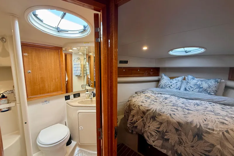 Slide: The Image of Luxurious 2003 Riviera 40 Flybridge yacht interior with cozy bedroom and modern bathroom. - 42