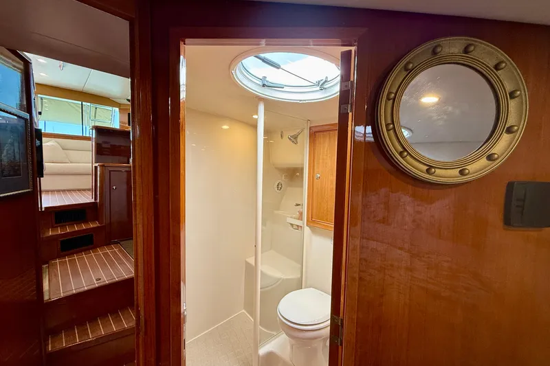 Slide: The Image of Interior of 2003 Riviera 40 Flybridge yacht, featuring a bathroom and wooden staircase. - 43