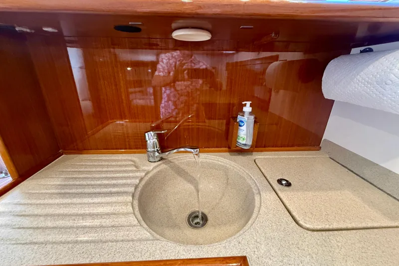 Slide: The Image of Kitchen sink area in 2003 Riviera 40 Flybridge yacht with wooden cabinetry. - 46