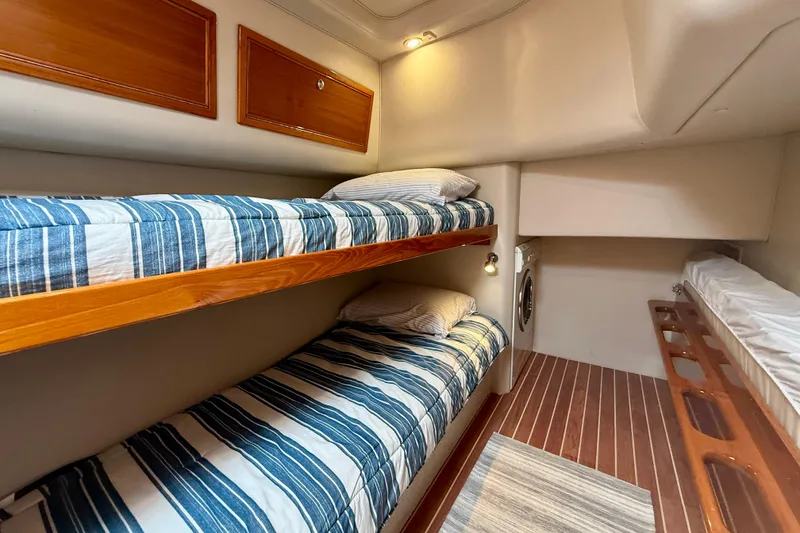 Slide: The Image of Bunk beds in 2003 Riviera 40 Flybridge yacht cabin with striped bedding. - 48