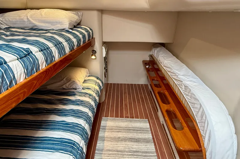 Slide: The Image of Interior cabin of 2003 Riviera 40 Flybridge with bunk beds and striped bedding. - 49