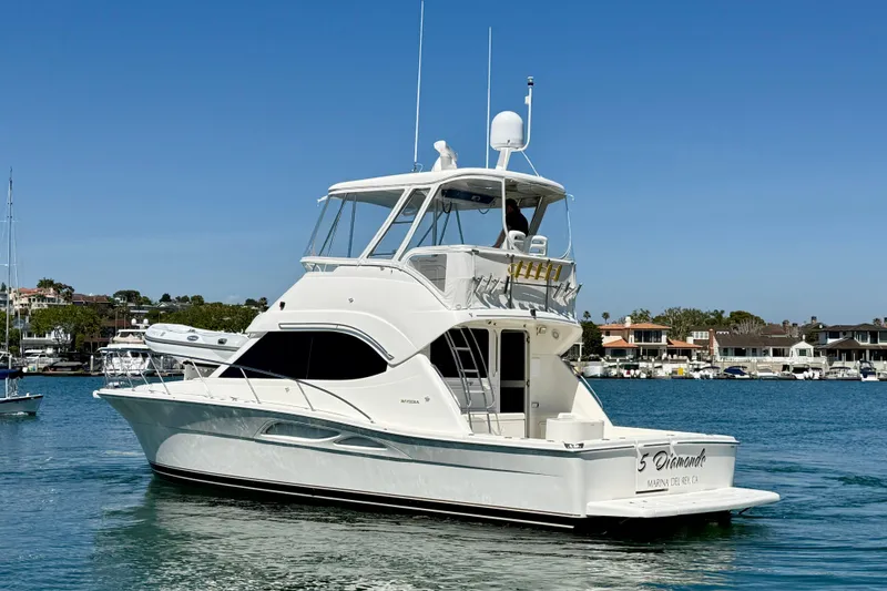 Slide: The Image of 2003 Riviera 40 Flybridge yacht on calm water, clear sky background. - 5