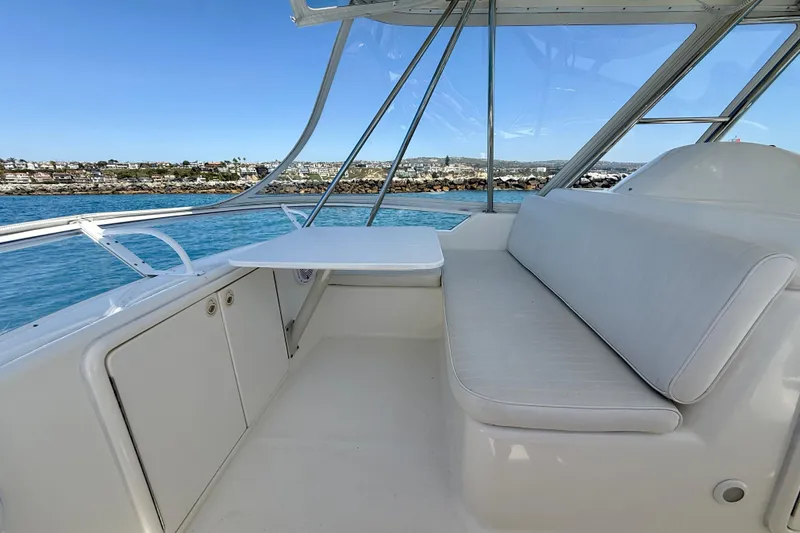 Slide: The Image of 2003 Riviera 40 Flybridge yacht interior with seating and table, overlooking scenic waterfront. - 70