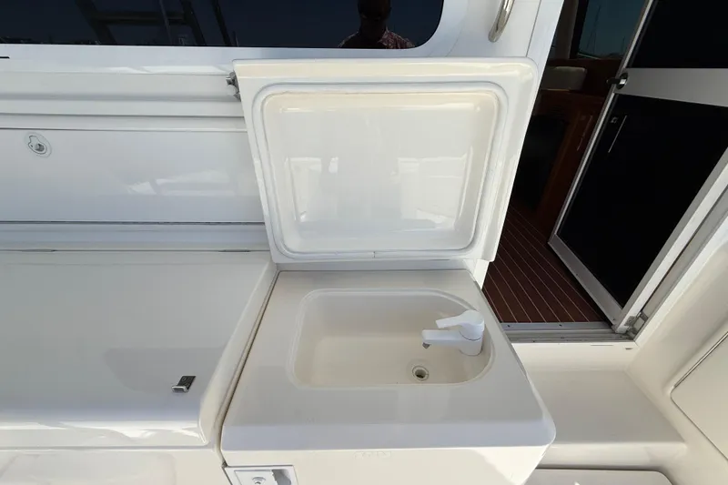 Slide: The Image of 2003 Riviera 40 Flybridge yacht sink with open lid and faucet. - 82