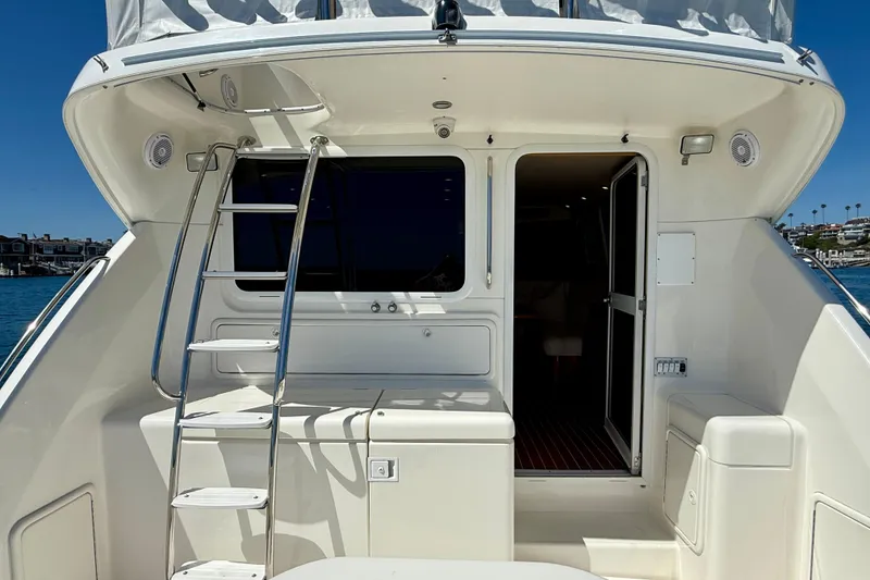Slide: The Image of 2003 Riviera 40 Flybridge yacht stern with ladder and open cabin door. - 94