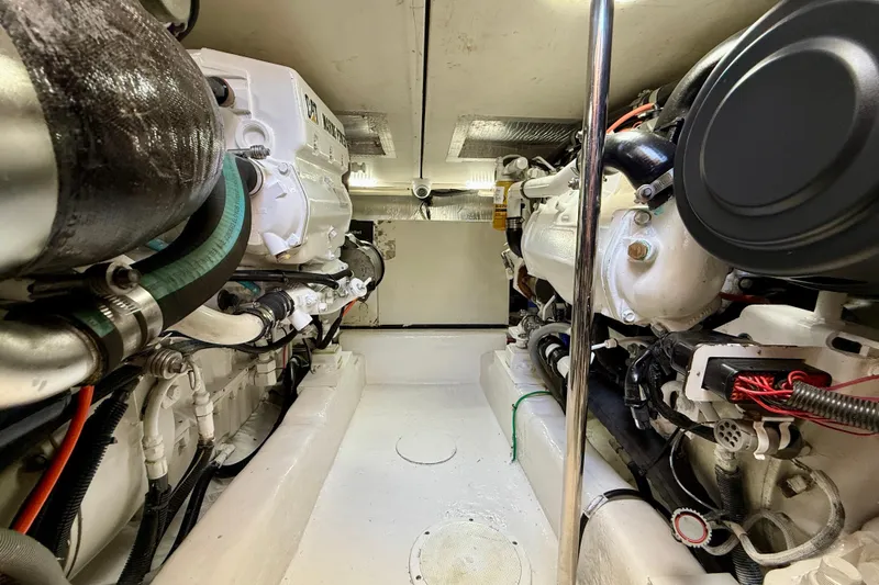 Slide: The Image of Engine room of a 2003 Riviera 40 Flybridge yacht, showcasing mechanical components and piping. - 98