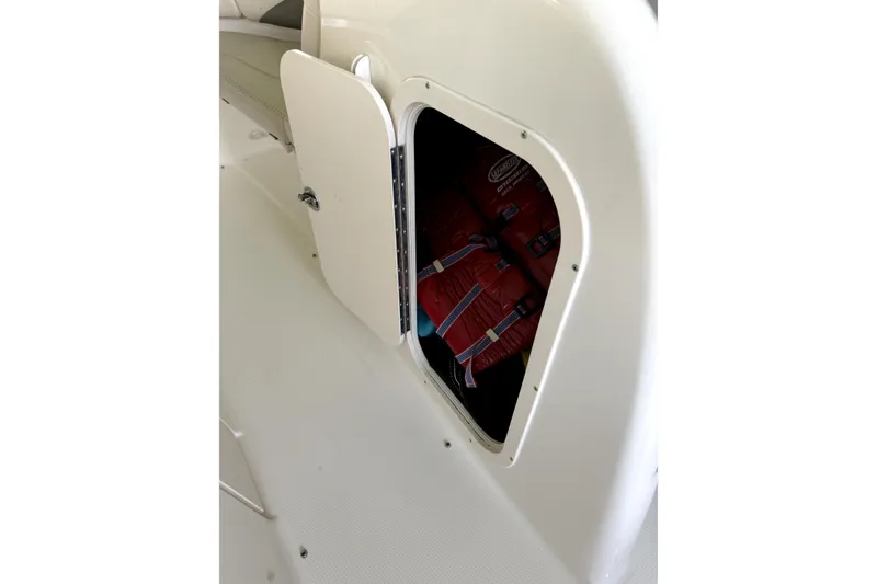 Slide: The Image of Open storage compartment on 2005 Chaparral 256 SSi boat with life jackets inside. - 11