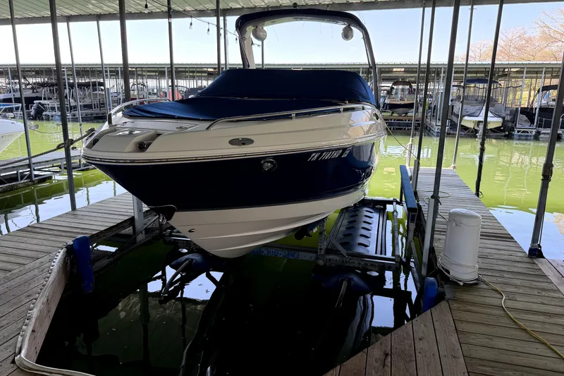 Slide: The Image of 2005 Chaparral 256 SSi boat docked in a marina with green water. - 2
