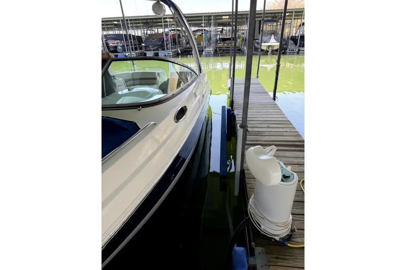 Slide: The Image of 2005 Chaparral 256 SSi boat docked at marina with green water. - 4