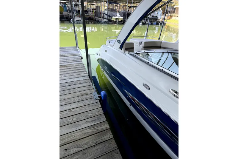 Slide: The Image of 2005 Chaparral 256 SSi boat docked at a marina with wooden planks. - 5
