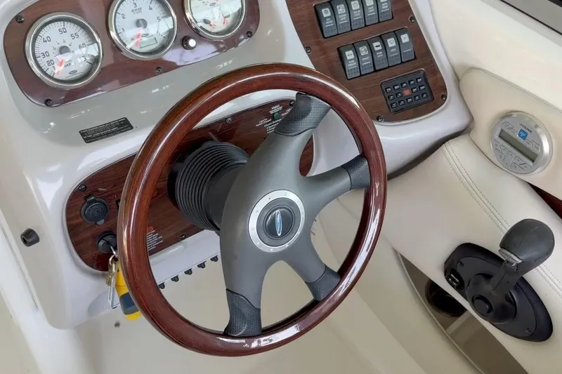 Slide: The Image of 2005 Chaparral 256 SSi boat dashboard with wood-trimmed steering wheel and control panel. - 7