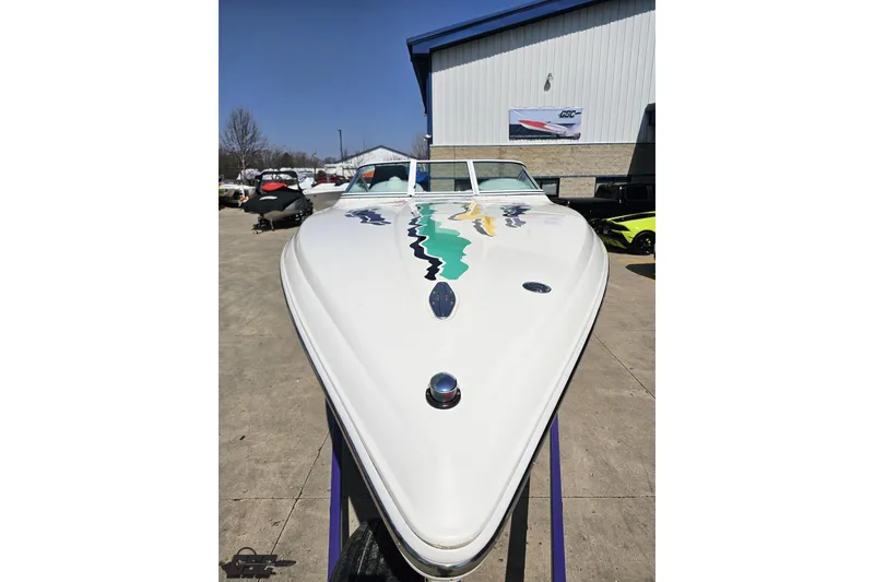 Slide: The Image of 2001 Powerquest 280 Silencer boat with colorful graphics, displayed outdoors. - 12