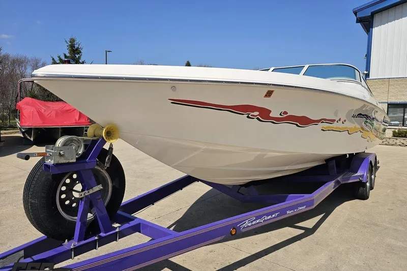 Slide: The Image of 2001 Powerquest 280 Silencer boat on a purple trailer, featuring vibrant graphics. - 15