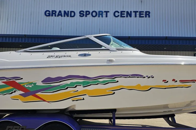 Slide: The Image of 2001 Powerquest 280 Silencer boat with colorful graphics at Grand Sport Center. - 3