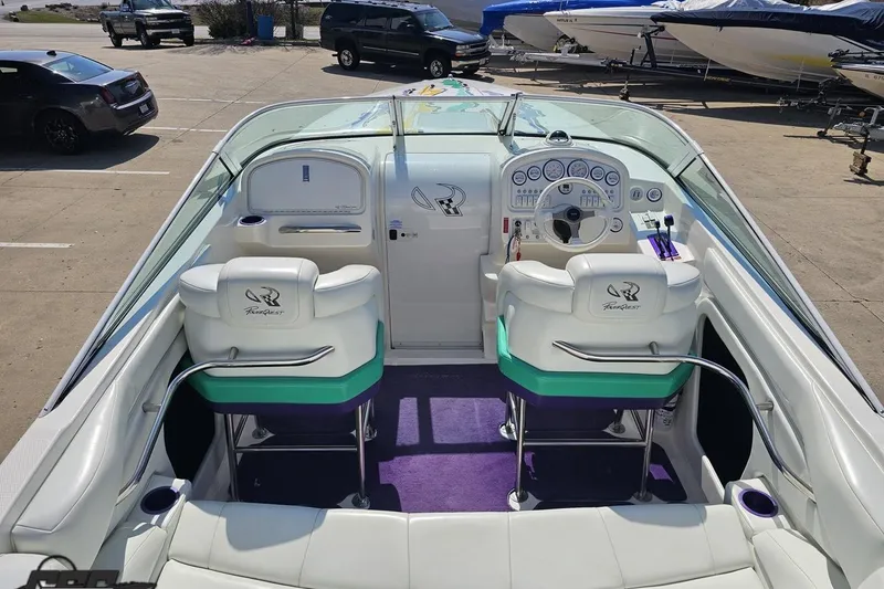 Slide: The Image of 2001 Powerquest 280 Silencer boat interior with white seating and dashboard controls. - 38