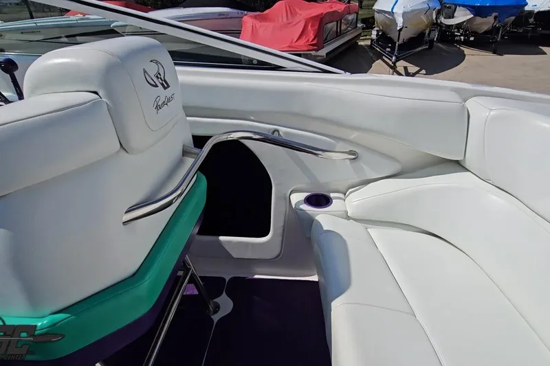 Slide: The Image of Interior of a 2001 Powerquest 280 Silencer boat with white seating and cup holder. - 42