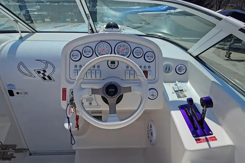 Slide: The Image of 2001 Powerquest 280 Silencer boat dashboard with steering wheel and control panel. - 44