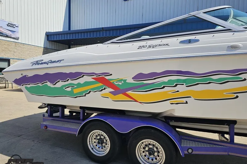 Slide: The Image of 2001 Powerquest 280 Silencer boat with colorful graphics on a trailer. - 5