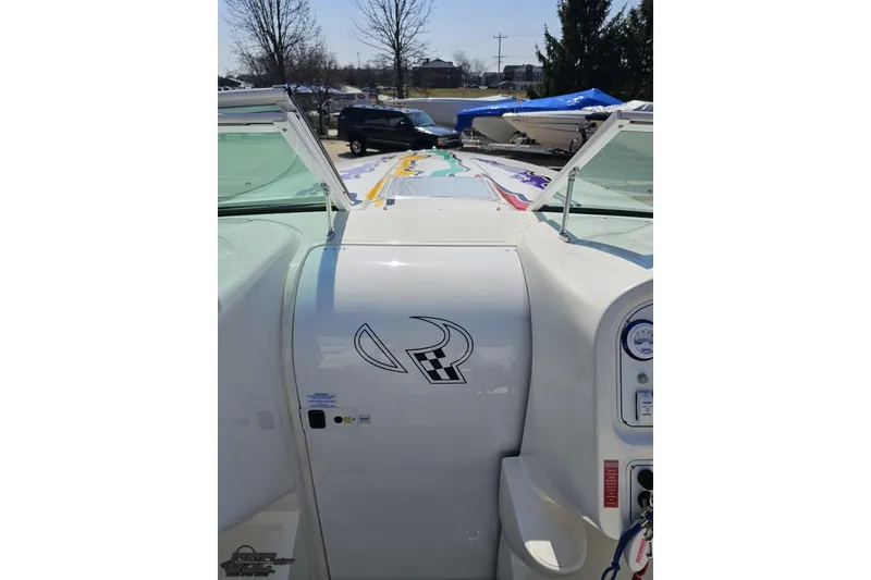 Slide: The Image of 2001 Powerquest 280 Silencer boat with open cockpit and colorful deck graphics. - 55