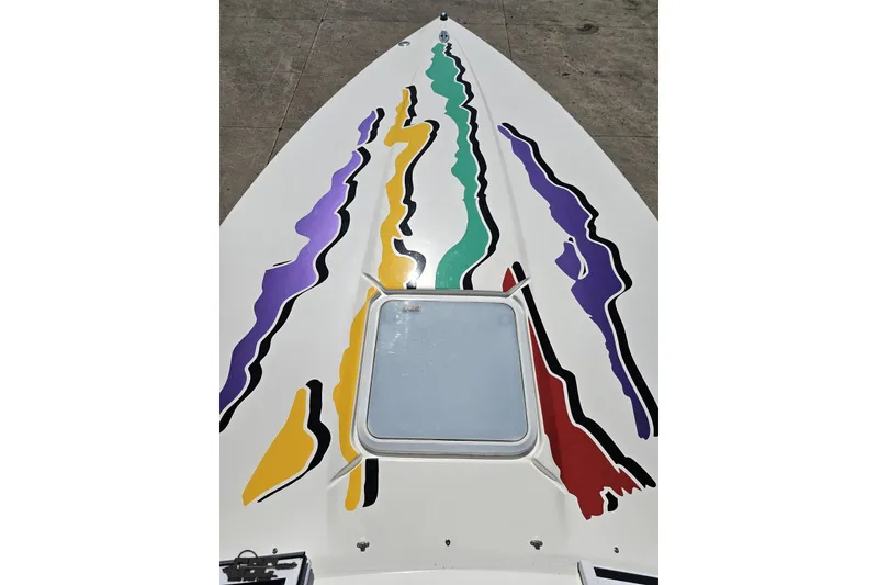Slide: The Image of 2001 Powerquest 280 Silencer boat with colorful abstract graphics on deck. - 57