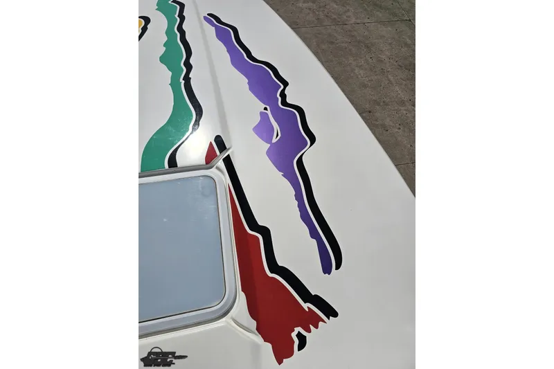 Slide: The Image of 2001 Powerquest 280 Silencer boat with colorful abstract graphics on deck. - 59