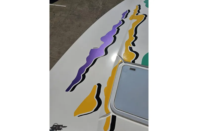 Slide: The Image of 2001 Powerquest 280 Silencer boat with colorful abstract graphics on deck. - 60
