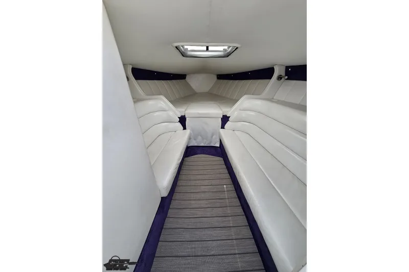 Slide: The Image of Interior of 2001 Powerquest 280 Silencer boat with white seating and overhead hatch. - 62
